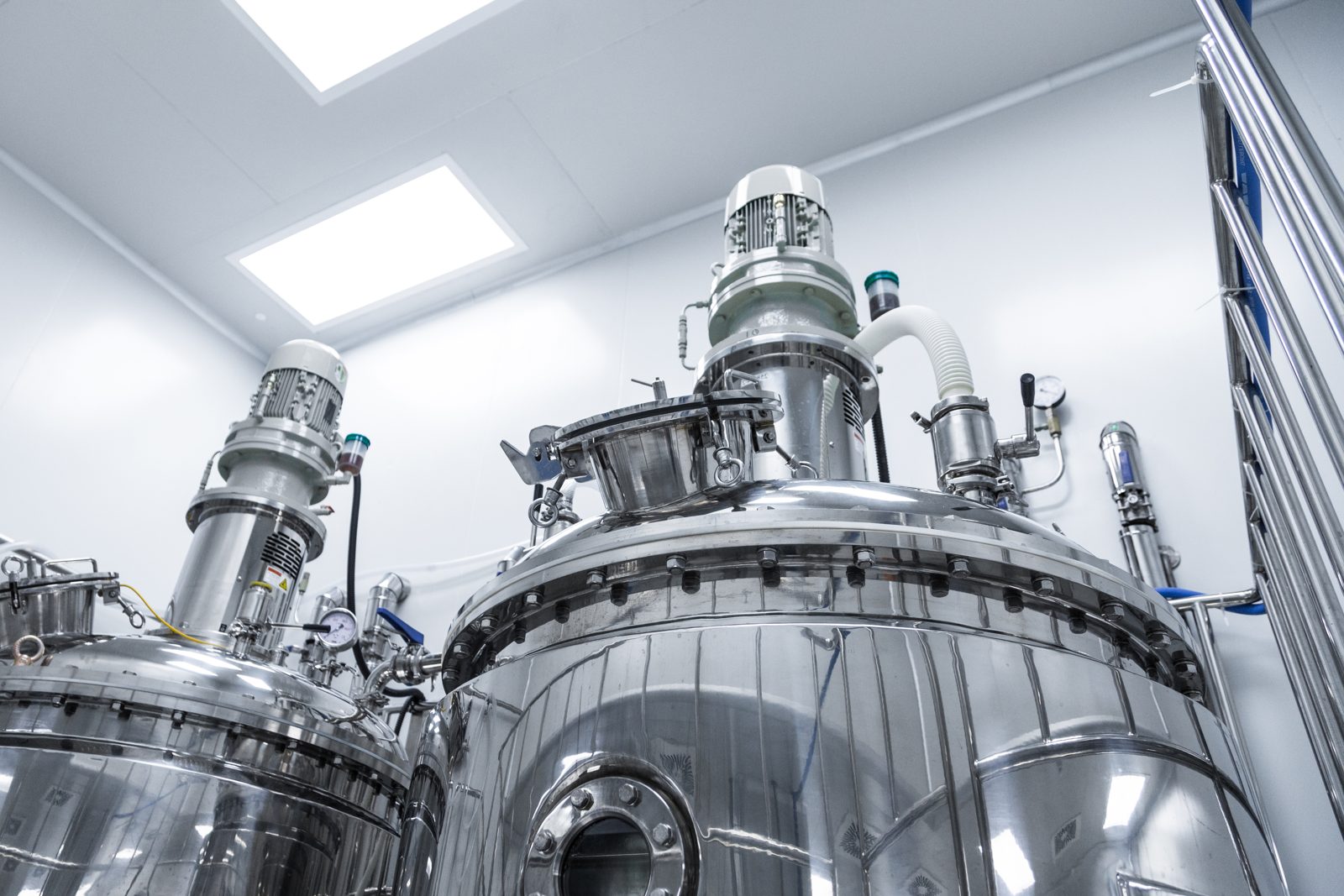 Stainless steel mixing tanks in a clean industrial environment, representing commercial chemical manufacturing